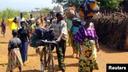 Des réfugiés congolais portant quelques biens arrivent au camp de Cibitoke, près de la frontière avec la RDC, au Burundi, 14 juin 2004.