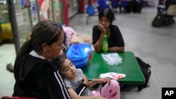 Iralba Bracho, una migrante venezolana llegada de Chile, sostiene a su nieta mientras espera ir a Maracaibo, en la terminal de autobuses La Bandera en Caracas, Venezuela, el domingo 7 de mayo de 2023.