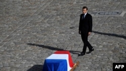 French President Emmanuel Macron stands in front of the coffin of former French president Jacques Chirac during a military tribute at the Invalides (Hotel des Invalides) in Paris, Sept. 30, 2019.