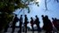FILE - Migrants stand stand in line at a respite center after they crossed the U.S.-Mexico border and turned themselves in and were released in Del Rio, Texas, June 16, 2021.