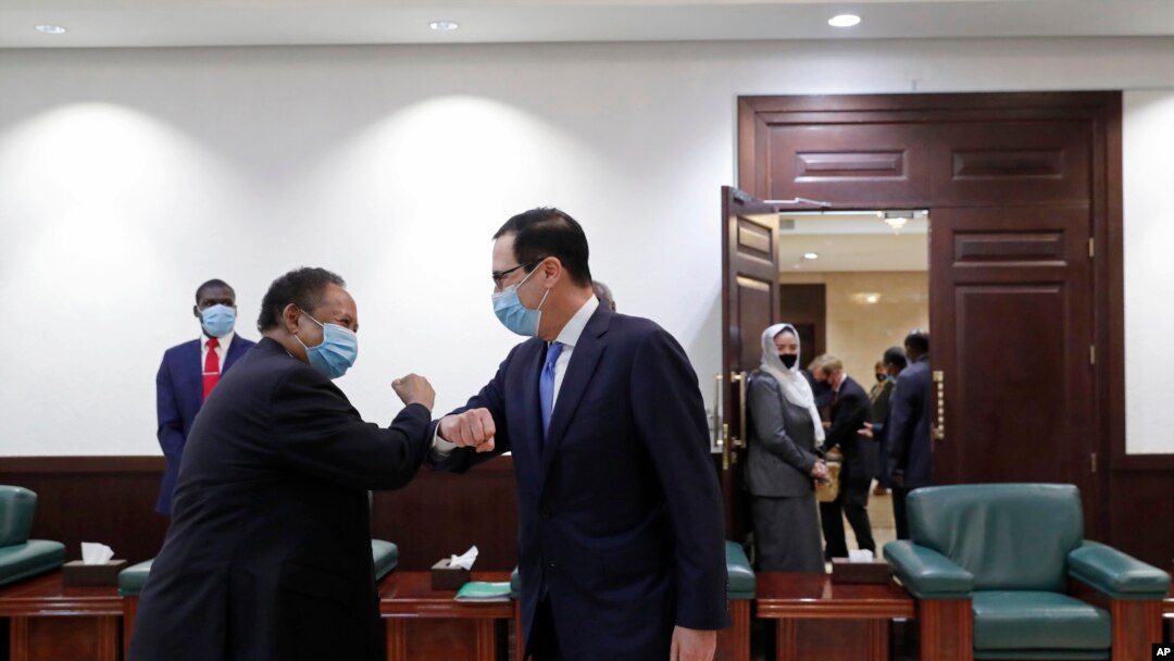 PM Sudan Abdullah Hamdok (kiri) menyalami Menteri Keuangan AS Steven Mnuchin (kanan) dengan saat tiba di Gedung Kabinet di Khartoum, Sudan, 6 Januari 2021.