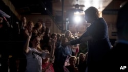 Le candidat démocrate Hillary Clinton salue les membres de l'auditoire lors d'un rassemblement au Lycée Theodore Roosevelt à Des Moines, Iowa, 28 octobre 2016.