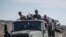 FILE - Ethiopian government soldiers ride in the back of a truck on a road near Agula, north of Mekele, in the Tigray region of northern Ethiopia, May 8, 2021. 