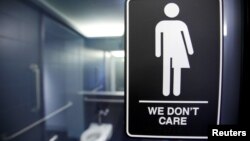 A sign protesting a North Carolina law restricting transgender bathroom access is posted on bathroom stalls at a hotel in Durham, N.C. on May 3, 2016.