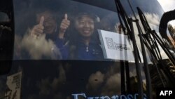 Venezuelan opposition deputies wave while traveling in a caravan of buses heading to the border with Colombia to bring in US-supplied humanitarian aid, in Caracas on Feb. 21, 2019. 