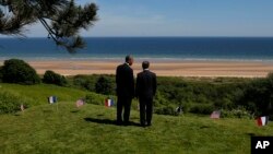 Presiden AS Barack Obama (kiri) dan Presiden Perancis Francois Hollande melihat ke arah pantai Omaha di Normandy, Perancis, salah satu tempat pendaratan tentara Sekutu pada PD II (foto: dok).