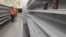 A woman walks between empty shelves of a supermarket in Caracas, Venezuela, Jan. 11, 2018. 