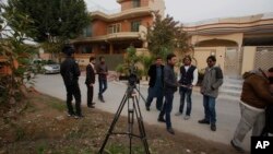 Pakistani journalists and local residents gather out the home of Salman Haider, a university professor and rights activists, following news of his return, in Islamabad, Pakistan, Jan, 28, 2017.