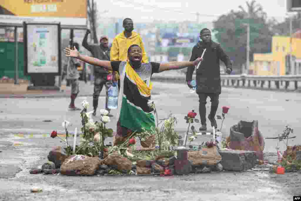 Supporters of the Optimist Party for the Development of Mozambique (PODEMOS) kneels over flowers placed in memory of two slain associates of the party during a strike called in Maputo.