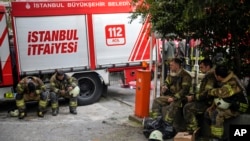 Firefighters rest in the aftermath of a fire in a nightclub in Istanbul, Turkey, April 2, 2024. The fire during renovations on Tuesday killed at least 29 people, officials and reports said. Several people, including managers of the club, were detained for questioning.