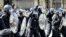 Police officers in riot gear gesture with batons during a demonstration held in reaction to the fatal stabbings in Southport on July 29, outside the Liver Building in Liverpool, England, on Aug. 3, 2024.