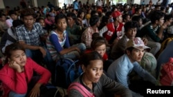 Cambodian workers wait for their documents to be processed at the Aranyaprathet police station as they prepare to move back to Cambodia in Sa Kaew, Thailand, June 15, 2014.