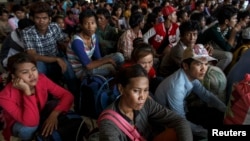 Cambodian workers wait for their documents to be processed at the Aranyaprathet police station as they prepare to move back to Cambodia, in Sa Kaew, Thailand, June 15, 2014.