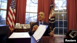 US President Barack Obama reacts as after signing the $1.1 trillion Government Funding Bill into Law at the Oval Office of the White House in Washington December 18, 2015.