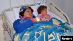 Una mujer y su hija heridas en lo que se cree fue un ataque con armas químicas son atendidas en un hospital de Siria.