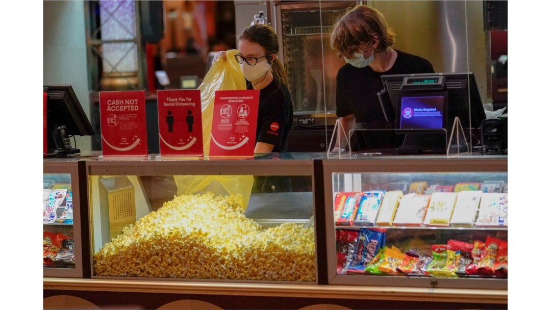 FILE - Concessions workers stock bins with popcorn and other treats as an AMC theater opens for some of the first showings since it shut down at the start of the COVID-19 pandemic, Aug. 20, 2020, in West Homestead, Pa.