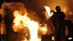 Perusuh melembarkan bom molotov ke arah polisi dalam kerusuhan di Belfast, Irlandia Utara Sabtu malam (13/7). 