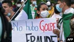 Una opositora al gobierno del presidente boliviano Luis Arce sostiene un cartel que dice "No fue un golpe, fue un fraude" mientras participa en una protesta contra el arresto de la expresidenta interina Jeanine Áñez y sus ex ministros. 15 de marzo 2021.