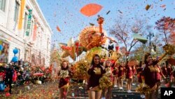 FILE - Performers cheer in front of Macy's Tom Turkey float as they take part in the 92nd annual Macy's Thanksgiving Day Parade in New York, Thursday, Nov. 22, 2018. (AP Photo/Eduardo Munoz Alvarez)