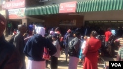 Vanhu vachimirira kutora mari dzavo mune rimwe bhanga muHarare. (Photo: Patricia Mudadigwa)