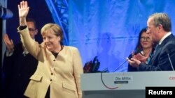 Nemačka kancelarka Angela Merkel maše dok stoji pored lidera svoje Hrišćansko-demokratske unije (CDU) Armina Lašeta, koji je i kandidat za kancelara, tokom predizbornog skupa u Štralsund, u Nemačkoj, 21. septembra 2021. (Foto: Reuters/Fabian Bimmer)