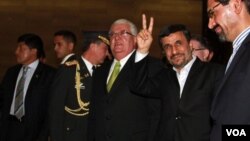 Presiden Iran Mahmoud Ahmadinejad mengacungkan tanda "V" (victory) saat tiba di Quito, Ekuador (13/1).