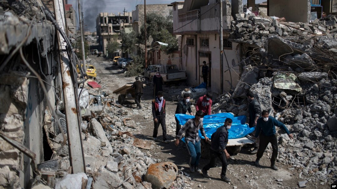 Warga setempat membawa jenazah beberapa korban yang tewas akibat serangan udara antara pasukan Irak dan ISIS di Mosul, Irak, 24 Maret 2017. (AP Photo/Felipe Dana, File)