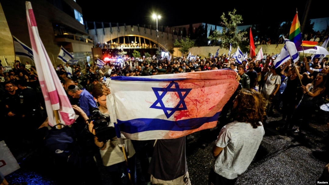 Manifestantes levantan la bandera de Israel en protestas masivas en Jerusalén contra la aprobación de partes de una reforma judicial el 24 de julio de 2023.