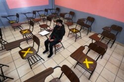 Seorang siswa duduk sendirian selama kelas tatap muka di sekolah menengah Republik Argentina di Iztacalco, Mexico City, Senin, 30 Agustus 2021. (Foto: AP)
