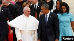 Pope Francis, left, is greeted by U.S. President Barack Obama and first lady Michelle Obama upon his arrival at Joint Base Andrews outside Washington, Sept. 22, 2015.
