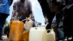 FILE - People sell black market fuel on the street in Lagos, Nigeria, Tuesday, May 30, 2023. Nigerian President Bola Tinubu has scrapped a decades long subsidy, leading to long lines at fuel stations as drivers scrambled to stock up before costs rise.