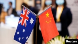 Bendera Australia dan China pada China International Import Expo di Shanghai, China, 6 November 2020. Australia menangguhkan pengaduannya ke WTO dalam upaya untuk membuka kembali pasar China bagi jelai Australia untuk pertama kalinya dalam tiga tahun. (Foto: Reuters)