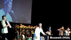 Richard Bennet (kiri) memainkan pianika dan isterinya Paula Jenine Bennet (baju putih) bernyanyi bersama para pemain instrumen etnik pada Yogyakarta Gamelan Festival 2015, Senin, 17 Agustus 2015 (Foto: VOA/Munarsih)