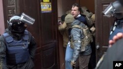 Ukrainian Security Service officers detain former Georgian president Mikheil Saakashvili at the entrance of his apartment building in Kyiv, Ukraine, Dec. 5, 2017. 