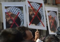 FILE - Indian activists carry placards of the leader of the Pakistan-based Jaish-e-Mohammad group, Masood Azhar, during a protest denouncing the attack on the Indian air force base in Pathankot, in Mumbai, India, Jan. 4, 2016.