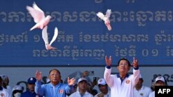 Cambodia's Prime Minister Hun Sen (R) and President of Cambodia's National Assembly Heng Samrin (L) release doves during a rally for the ruling Cambodian People's Party (CPP) ahead of the upcoming election in Phnom Penh on July 1, 2023.