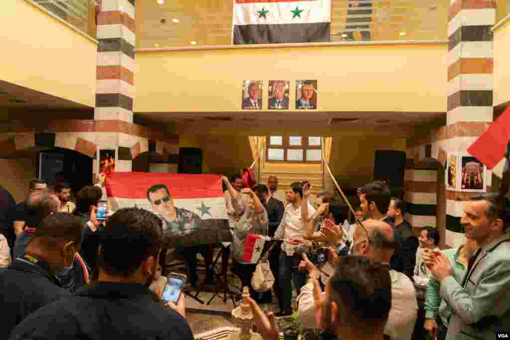 Quarters of the Syrian embassy in Cairo are cramped with patriotic Syrians singing national songs and raising Syrian flags depicting Bashar al-Assad. (H. Elrasam/VOA)