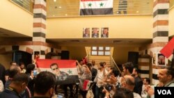 Quarters of the Syrian embassy in Cairo are cramped with patriotic Syrians singing national songs and raising Syrian flags depicting Bashar al-Assad. (Hamada Elrasam/VOA)