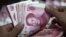 A bank clerk counts Chinese banknotes at a branch of Industrial and Commercial Bank of China in Huaibei, Anhui province, June 8, 2012. 