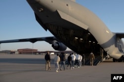 Agentes de Aduanas y Protección Fronteriza de EE. UU. guían a inmigrantes indocumentados a bordo de un avión C-17 Globemaster III asignado al 60.º Ala de Movilidad Aérea para un vuelo de deportación en Fort Bliss, Texas, el 23 de enero de 2025.