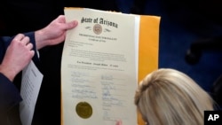 FILE - The certification of Electoral College votes for the state of Arizona is unsealed during a joint session of the House and Senate convenes to confirm the electoral votes cast in November's election, at the Capitol, Jan 6, 2021.