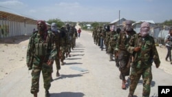 FILE - Members of Somalia's al-Shabab militant group patrol on foot on the outskirts of Mogadishu, Somalia, March 5, 2012.