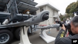 Seorang reporter sedang memotret drone Tracking UAV di Institut Nasional Sains dan Teknologi Chung Shan di Kota Taichung, Taiwan, 14 Maret 2023. (Foto: Chiang Ying-ying/AP Photo)