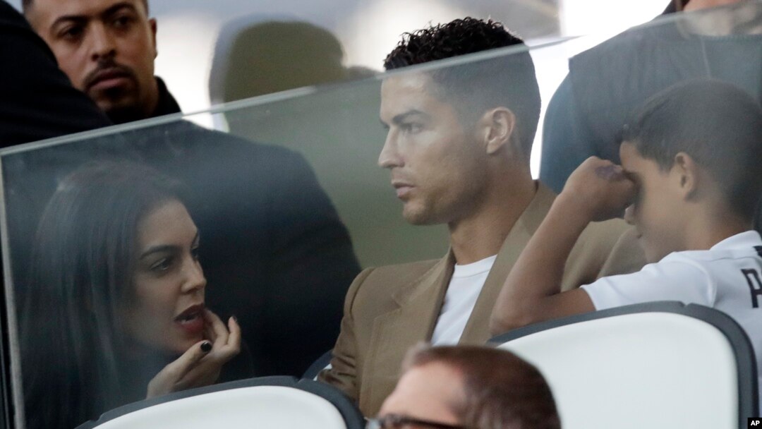Penyerang Juventus, Cristiano Ronaldo (tengah), bersama pasangannya Georgina (kiri) dan putranya Cristiano Jr, saat menyaksikan laga penyisihan Grup H antara Juventus dan Young Boys, di Stadion Allianz di Turin, Italia, 2 Oktober 2018.