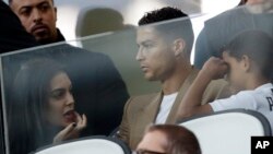 Penyerang Juventus, Cristiano Ronaldo (tengah), bersama pasangannya Georgina (kiri) dan putranya Cristiano Jr, saat menyaksikan laga penyisihan Grup H antara Juventus dan Young Boys, di Stadion Allianz di Turin, Italia, 2 Oktober 2018.