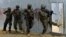 Masked Somali national army (SNA) soldiers search through homes for al-Shabaab fighters, during an operation in Ealsha Biyaha, Somalia, Saturday, June, 2, 2012.