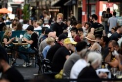 Customers eat sunday lunches at tables outside restaurants in Soho, in London. Sept. 20, 2020.