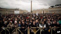 Visitors wait for the chimney smoke in St. Peter's Square during the second day of the conclave to elect a new pope, at the Vatican, Mar. 13, 2013.