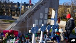 উইসকনসিনের ওয়াকেশায় রবিবার ক্রিসমাস প্যারেডের সময় একটি  এসইউভি গাড়ির ধাক্কায় নিহত পাঁচজনের স্মরণে নির্মিত স্মৃতিসৌধতে শ্রদ্ধা জানাচ্ছেন পরিবারের সদস্যরা।২৩ নভেম্বর ২০২১। (ছবি-এপি/জেফ্রি ফেল্পস) 