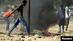 FILE - Sudanese demonstrators light a fire as they participate in anti-government protests in Khartoum, Sudan, Jan. 25, 2019.